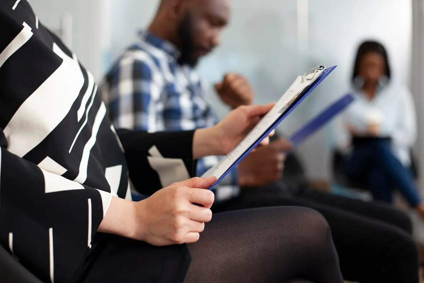 Vrouw die een klembord vasthoudt in de lobby van een kantoor